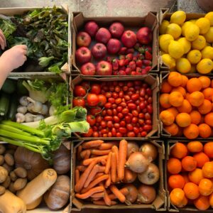 Top view of vibrant fruits and vegetables in boxes, showcasing variety and color.