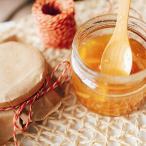 Delicious homemade citrus jam in a jar with a wooden spoon, perfect for breakfast spreads.